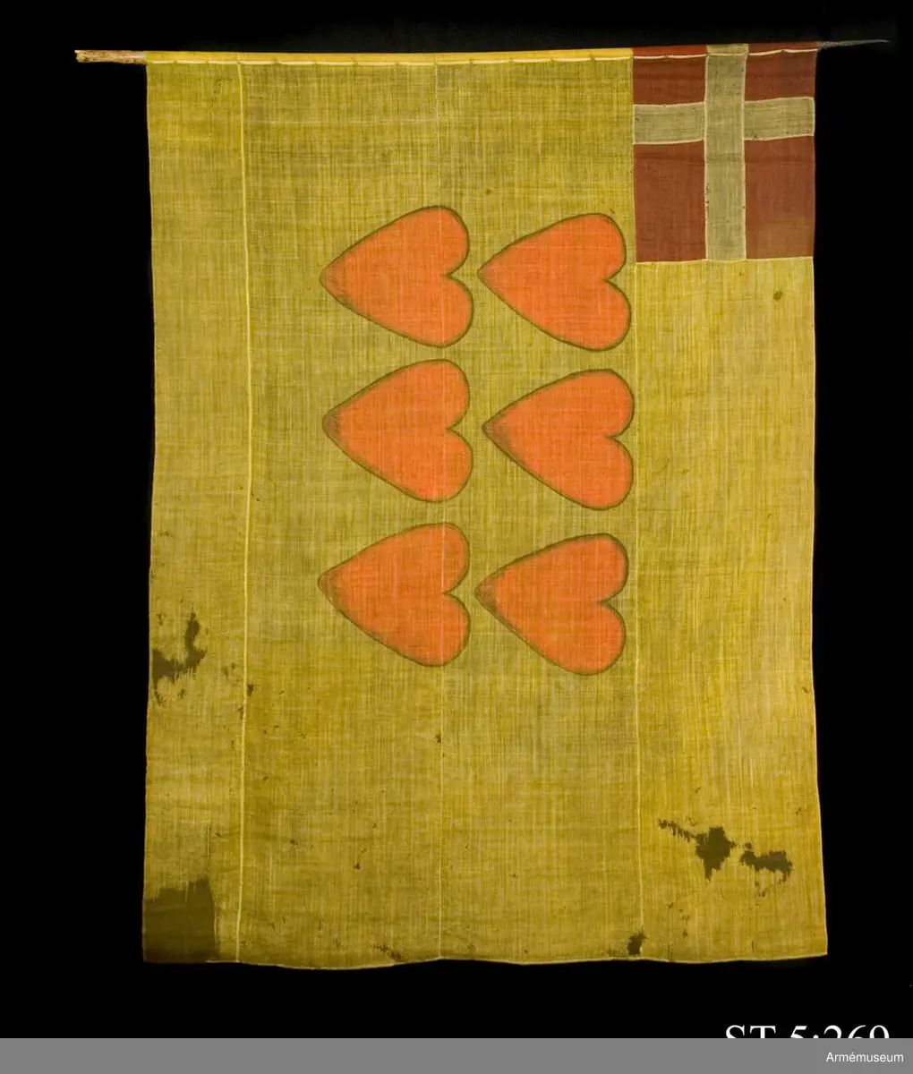 Ylleduk med infällning och målning.

Upptill vid stångsidan infälld Dannebrogen . Mitt på duken målat sex hjärtan i två rader.