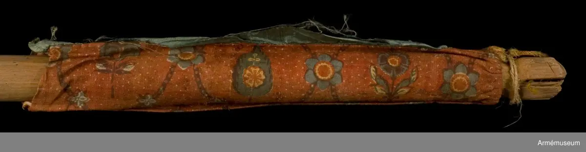 Duk av ljusblå kinesisk sidendamast med målad dekor föreställande helgonet Demetrius av Thessaloniki och slingor av blommor. Strumpa av rött linne.