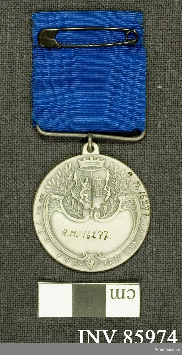 Grupp M. 
Åtsidan: = nr. 16276.
Frånsidan: = nr. 16276, med den skillnad, att något namn icke är inristat på denna medalj.
I bandhållaren ett mellanblått m.m. brett ripsband..

