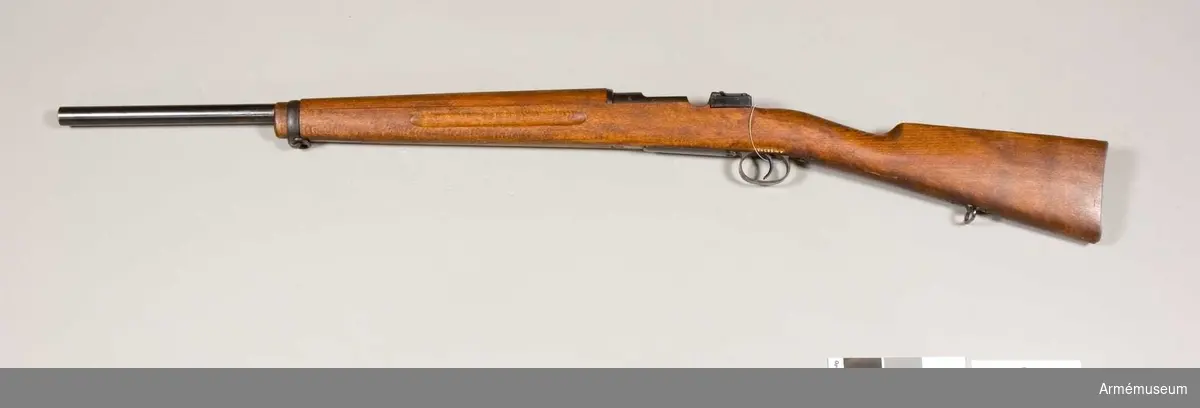 Grupp  E II f
Gevär. 7,9 mm. Geväret är kamrat för svenska 8 mm kulsprutepatroner m/1932 samt har ovanligt tjock, 60 cm lång pipa. I övrigt liknar vapnet AM.022336, men har aldrig haft några siktmedel. Geväret torde ha varit avsett för ammunitionsprovning. På lådans vänstra sida står 29/34 MAX och på hävarmsknappen 26/34. På flertalet av vapnets övriga delar är numret 26 inslaget.Se även AM.030519.
Tnr 27/34, 1932. ej sls.