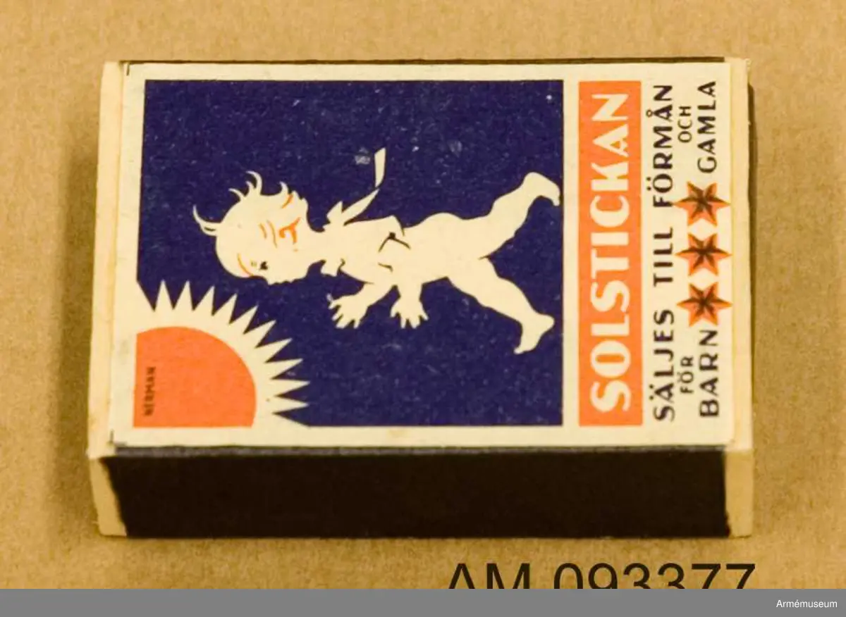 Tändsticksask med tändstickor. På ena sidan motivet Solstickan och på andra sidan ett motiv som illustrerar hur en spionhand sträcker sig över en husbyggnad nattetid. 