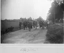 Civila män, studenter, promenerar med packning på landsväg, efter avslutad militärtjänstövning?,Uppsala 1895.