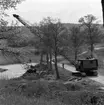 Av den medeltida fästningen Rumlaborg återstår ännu höga vallar, som kan ses från motorvägen genom Huskvarna. Denna bild från början av 1960-talet visar grävningsarbeten intill borgen. Grävmaskinen körs av Harald Fransson och vid vägkanten står stadsträdgårdsmästare Erik Letell och övervakar arbetet.