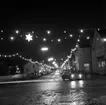 Julskyltning på Rosenborgsgatan i Huskvarna i december 1962. Ut på Drottninggatan svänger en blänkande Volvo Amazon.