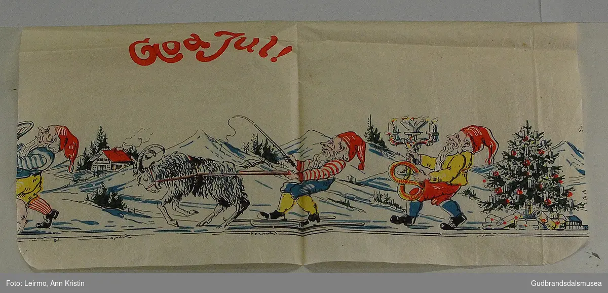 Et lite stykke av en lang juleløper med julemotiv av nisser, juletre, dyr på ski. Ble festet på veggen med tegnestifter.