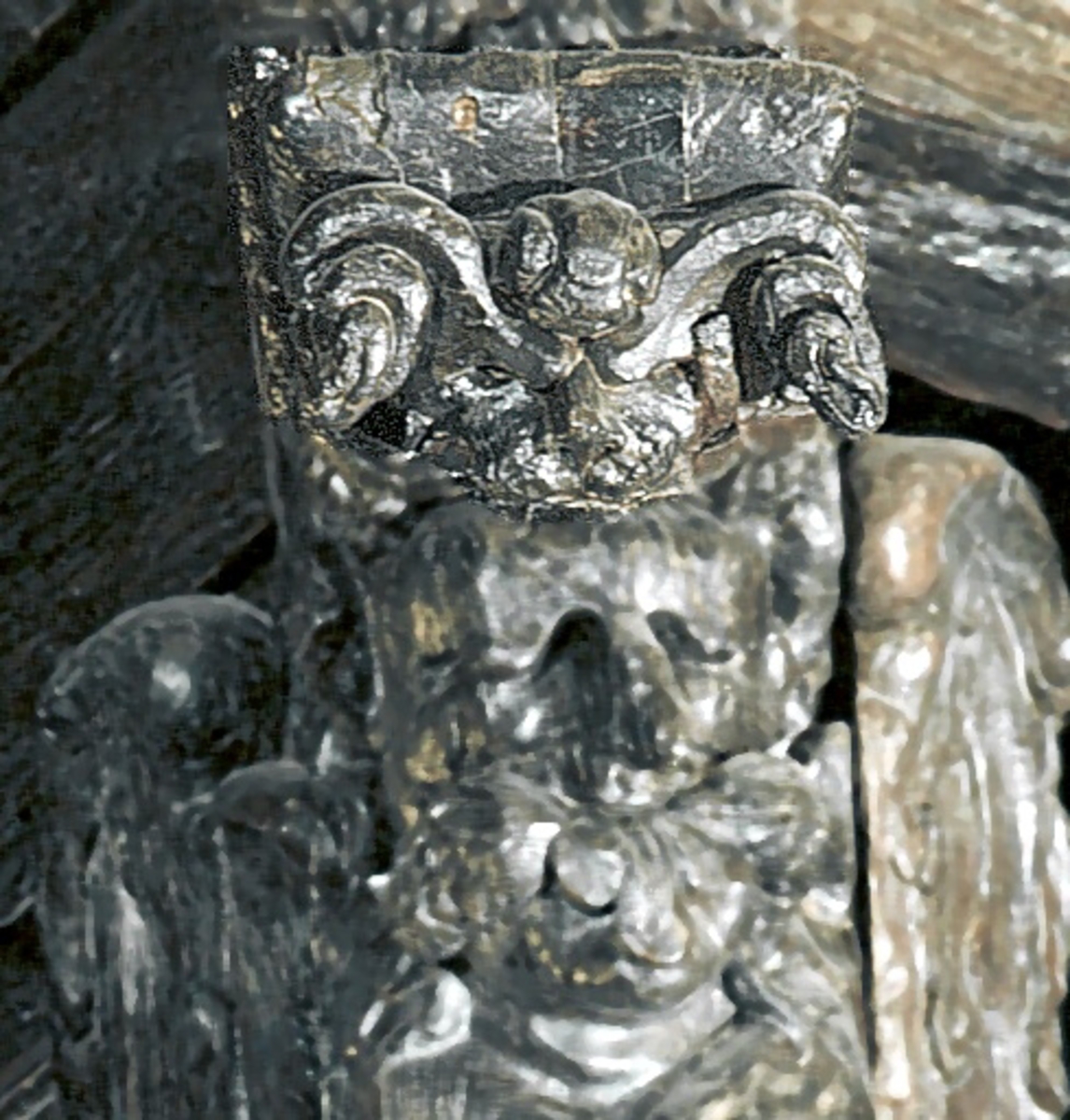 Skulpturdel i form av ett bock- eller vädurshuvud. Relativt välbevarad.

Text in English: Part of sculpture in the shape of a billygoat''s or ram''s head. Relatively well preserved.