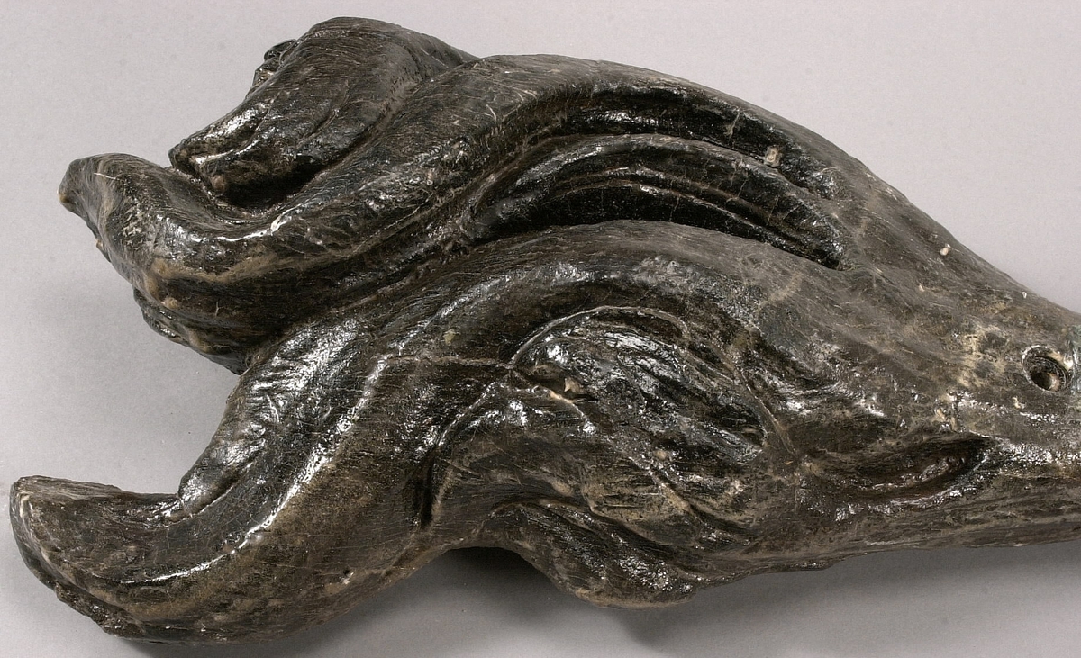 Skulpterad lejonsvans, lagad i rotändan. Svanstofsen är stor och yvig. Svansens baksida är slät.

Text in English: A sculpted lion''s tail, broken off where it was attached to the lion''s hind quarters. The tuft is large and bushy. The reverse side is smooth.