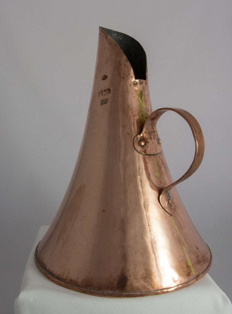 Mått, kanna, av förtent koppar med konisk form och nitat handtag. Volymmått för 2,62 l. Krönt och stämplat: 1853, PB.