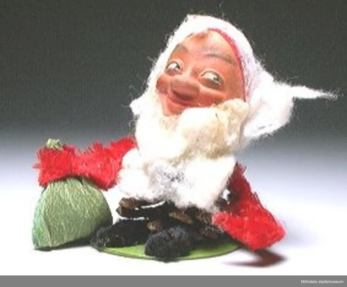 Sex tomtefigurer, tillverkade av flörtkulor kottar och piprensare, en figur består av en stege med två tomtar och en måne.Ingår i Holtermanska samlingen.Märkta med Mm 2859-1-6.