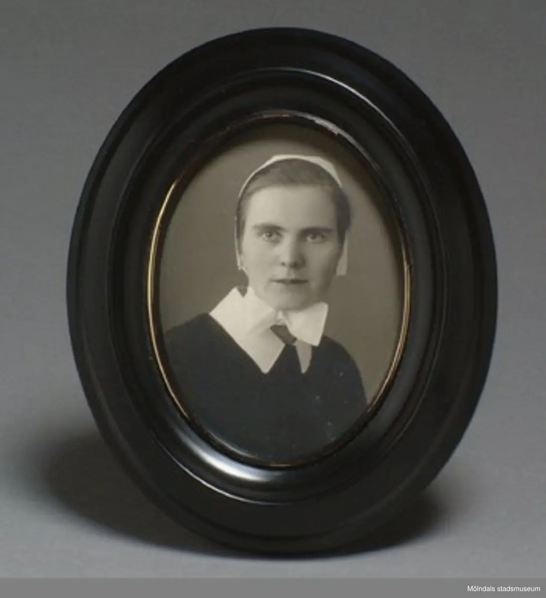 Inramat foto av Helga Andreasson.Helga Andreasson växte upp i Mölndal och efter avslutad skolgång utbildade hon sig till sjuksköterska och diakonissa vid Bräcke diakonianstalt. År 1931 reste hon ut till Zululand i Sydafrika och arbetade där som missionär för Svenska Kyrkans Mission. I närmare 40 år kom Helga Andreasson att arbeta i Sydafrika med kyrka och mission. Givaren Lilly Nygren är syster till Helga Andreasson, som var äldsta systern i en barnskara av sex.Foton, diabilder, böcker mm. efter Helga Andreasson finns förvarade i Föreningsarkivet i Mölndal.