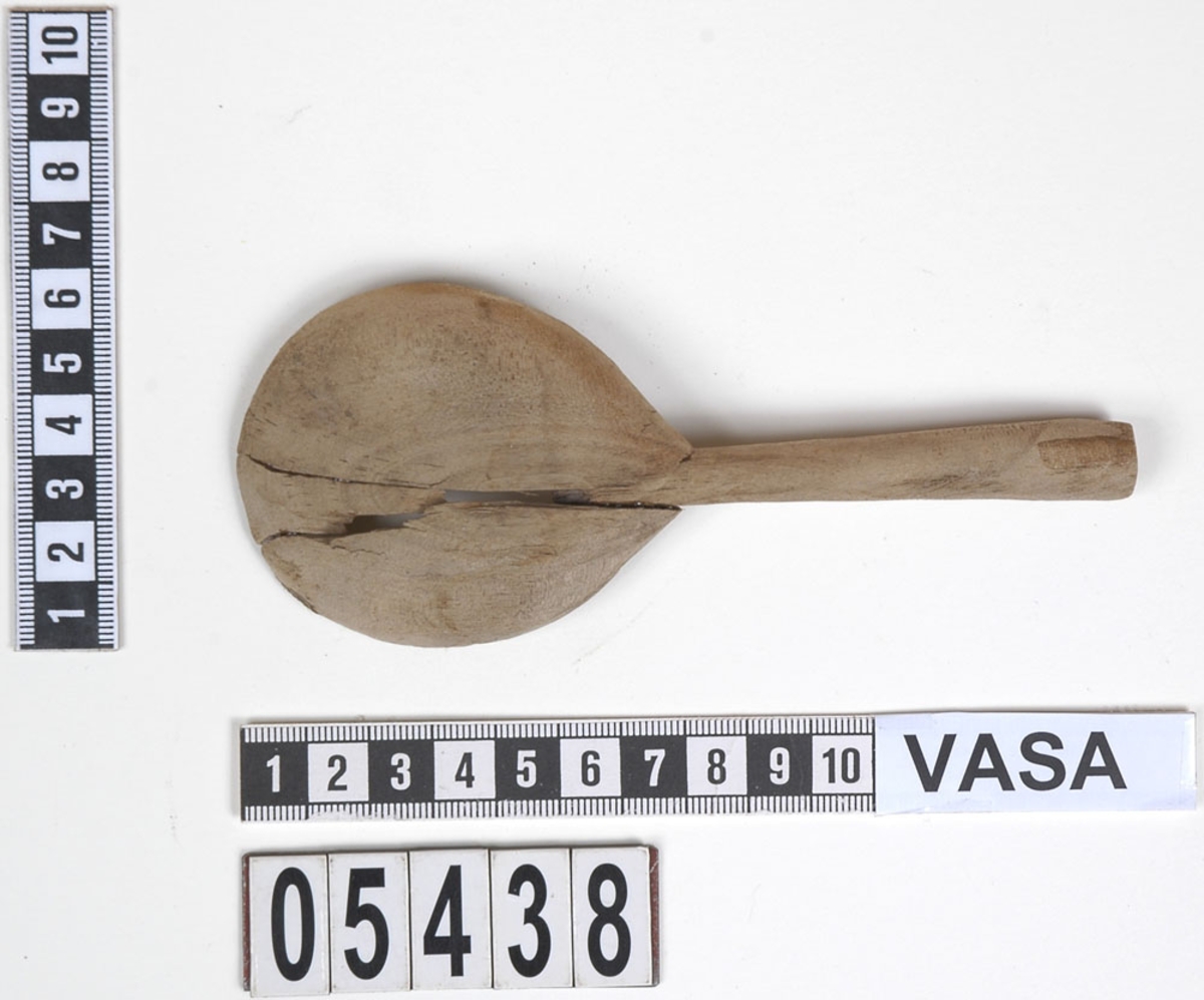 En träsked som tidigare var bruten i fyra delar. En av delarna utgör skaft samt mindre parti av skedblad. De tre övriga är delarna av skedbladet.
Idag är delarna sammanfogade och i sin helhet har skeden ett runt skedblad och ett rakt skaft där tvärsnittet är något ovalt.
Skeden är mycket ömtålig. Ett mindre parti av skedbladet saknas.