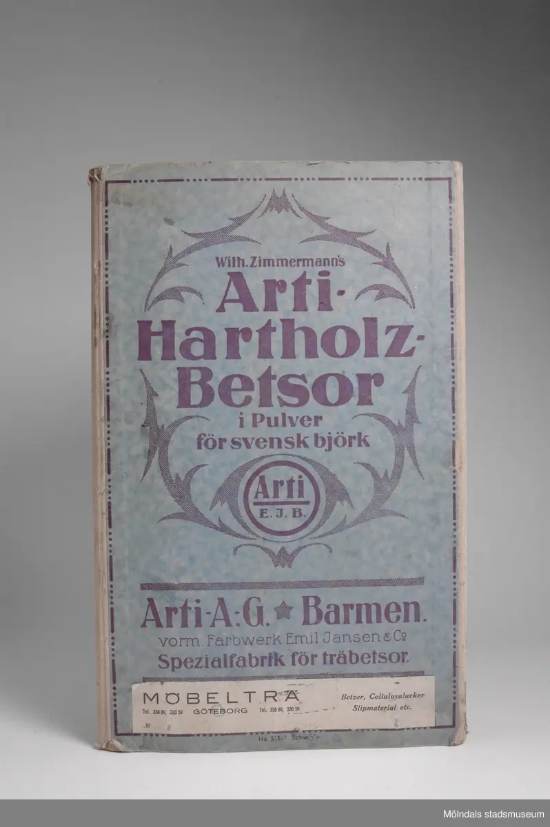 Provkarta med möbelfärger från tyska Art A.G./Barmen, Specialfabrik för träbetsor.Redskap och verktyg kommer från Lindströms snickeri (Gamla Riksvägen 81, Ekebacken). Här byggde John Lindström från Lindome ett boningshus och snickeriverkstad 1928. Han öppnade ett snickeri som specialiserade sig på köksbord Borden levererades till en grossist i Göteborg. Som mest tillverkades 50-60 bord i veckan. Borden hade ben av björk och resten var av furu. Han gjorde även andra möbler på beställning. Till hjälp hade John ett par anställda.De sista åren gjordes mest renoveringar och reparationer, medan det "begav sig" de mest aktiva åren tillverkades bord av alla de slag.