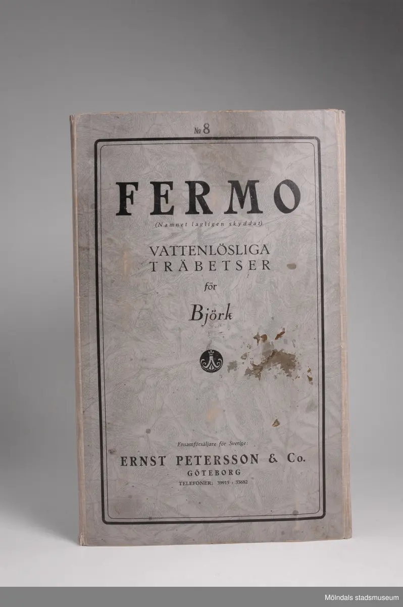 Provkarta med möbelträbetsfärger.Redskap och verktyg kommer från Lindströms snickeri (Gamla Riksvägen 81, Ekebacken). Här byggde John Lindström från Lindome ett boningshus och snickeriverkstad 1928. Han öppnade ett snickeri som specialiserade sig på köksbord Borden levererades till en grossist i Göteborg. Som mest tillverkades 50-60 bord i veckan. Borden hade ben av björk och resten var av furu. Han gjorde även andra möbler på beställning. Till hjälp hade John ett par anställda.De sista åren gjordes mest renoveringar och reparationer, medan det "begav sig" de mest aktiva åren tillverkades bord av alla de slag.