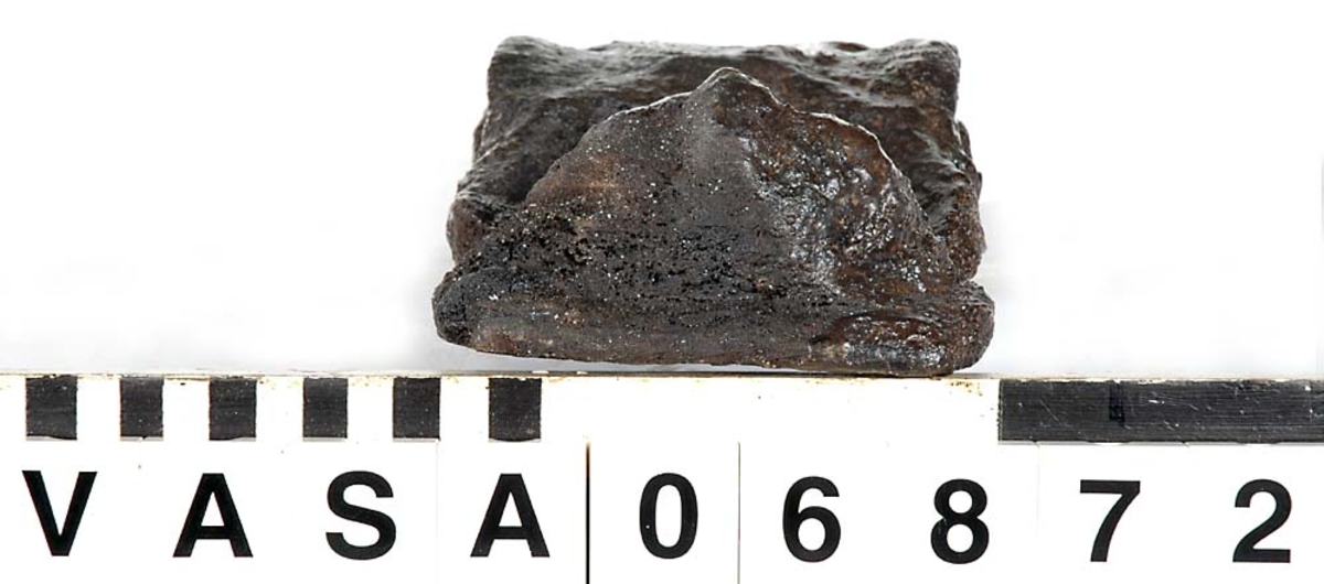 Liten skulpterad pilaster, troligtvis utformad som en karyatid eller möjligen en putto. Figuren har långt hår och ett knubbigt ansikte, omgivet av en bred krage. Det nedåt avsmalnande pilasterskaftet är dekorerat med akantusblad. Nedtill avslutas pilastern av en rikt profilerad och dekorerad sockel. Skulpturens baksida är slät.

Skulpturen är sliten, pilasterns nedre del är dock mindre sliten än den övre.



Text in English: A small carved pilaster, with a caryatid or probably a putto. The figure has a chubby face, long hair and a broad collar. The lower part of the pilaster is decorated with acanthus leaves. The caryatid stands on a richly profiled and decorated socle. The back of the sculpture is smooth.

The sculpture is worn, the lower end less so than the upper.