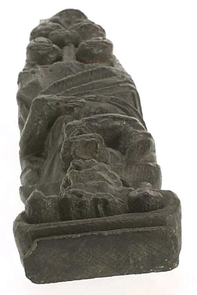Hermpilaster.
Liten skulpterad pilaster föreställande skäggig herm under joniskt kapitäl.
Huvudet är vridet mot vänster. Hermen är insvept i en mantel som hålls fast med vänster hand framför magen. I höger hand håller figuren ett okänt föremål (blomsterkälk?) framför bröstet. Pilasterskaftet är prytt med stora frukter och blad, fasthängande vid en stängel som delvis täcker det nedåt avsmalnande skaftets ramverk. Baksidan är slät.
Skulpturen är mycket välbevarad med sju spikhål.

Text in English: Small sculpted pilaster with a bearded Herm beneath an Ionic capital.
The head of the figure is turned to the left. The Herm is enveloped in a mantle, held fast with the left hand in front of its stomach. Its right hand holds an unknown object (a bunch of flowers?) in front of its breast. The shaft of the pilaster is decked with large fruit and leaves hanging from a stalk which partly cover the framing of the tapering shaft. Its back is flat.
The sculpture is very well preserved.