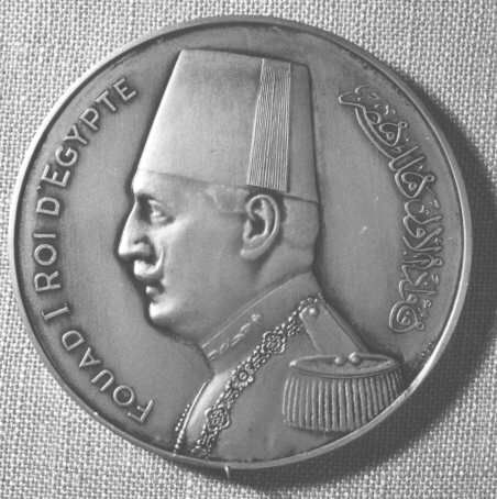 Medalj i brons, rund, präglad med anledning
avVärldspostföreningens kongress i Kairo, Egypten år 1934. På
åtsidanett porträtt i profil av Egyptens kung Fouad I, samt text
enligt MRK.Frånsidan visar en avbildning av Världspostmonumentet i
Bern, Schweiz.