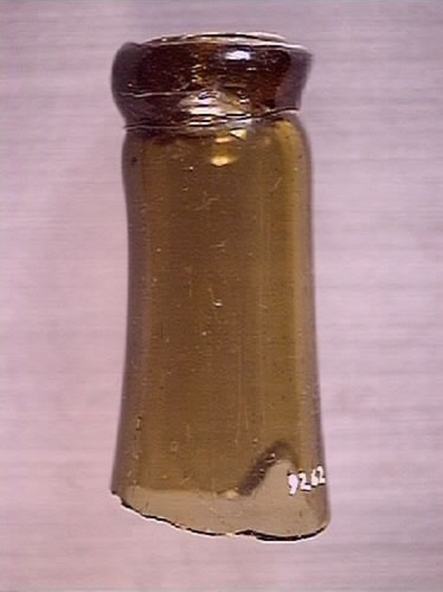 En flaskhals samt en glasskärva.  Flaskhalsen är brunfärgad. Vid flaskmynning ligger glassträngen omlott. Glasbiten är grönfärgad. Troligtvis rör det sig om skärva från flaskans buk. Flaskhalsen och glasskärvan härrör från två olika flaskor.

09262a: Finish has laid-on ring, common on bottles before 1850s (https://sha.org/bottle/finishes.htm), finish also has possible mold line, possibly intrusive artifact. Glass is olive color.
09262b: Glass is dark green.