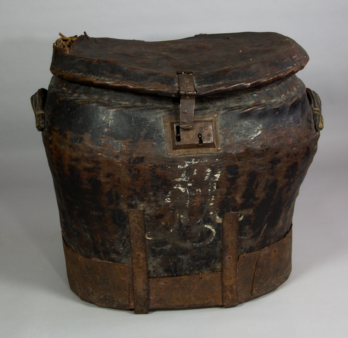 Reskoffert med lock av flätad korg klädd med läder, med järnband längs sidorna och kring foten. På sidorna bärhandtag av läder. Med beslag och lås av järn. På framsidan ett stort målat "M" alternativt "L U" i vitt.