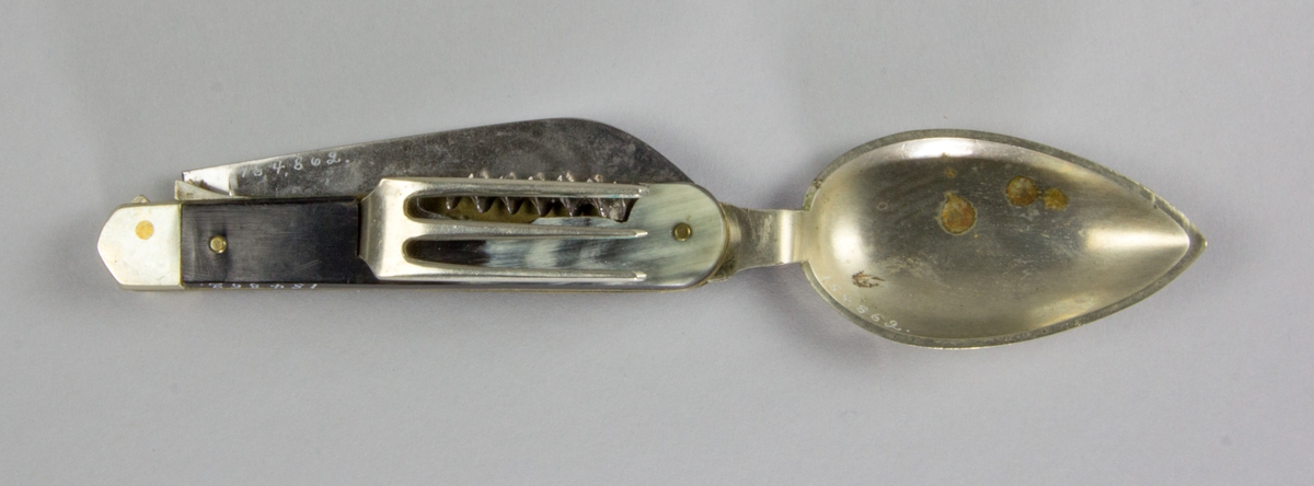 Bestick, fällkniv med handtag av horn och knivblad av stål, sked och gaffel av försilvrad metall, samt dessutom korkskruv och handskknäppare. Signerad: '59 Sauvagnat'.