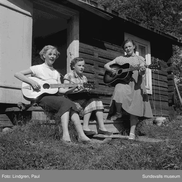 Fäbod i Norrböle, Attmar. Tre kvinnor spelar gitarr och cittra, kvinna med kossor.