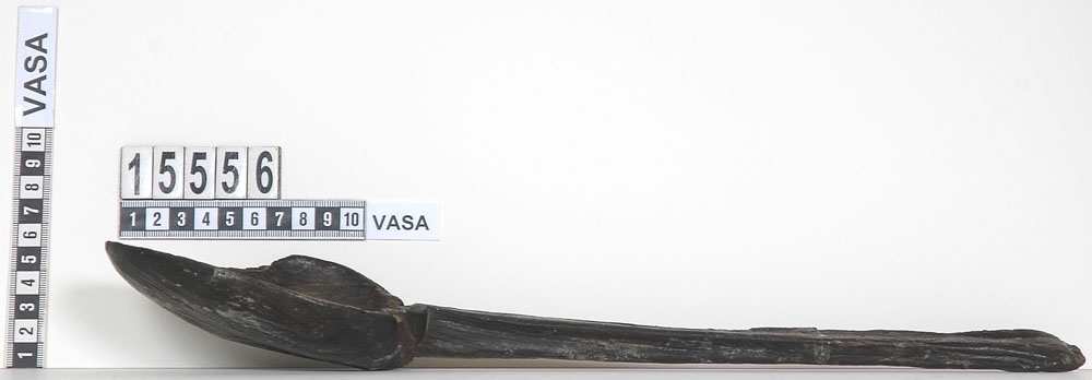 En träslev.

Sleven har tidigare varit bruten i fyra delar: skedblad samt tre skaftdelar. Skedbladet är ovalt och skaftet rakt med fyrkantigt tvärsnitt. I änden på skaftet, på undersidan, sitter ett bomärke. Skedbladet är brutet längs med kanten och har en synlig spricka. På den ena skaftdelen syns spår efter en lagning från tiden efter bärgningstillfället. Skedbladet och den längre delen av skaftet fogades samman av konserveringsenheten 1997 och idag består sleven av två delar.

Sleven tycks ha varit utsatt för kraftigt vattenslitage.