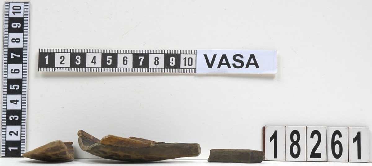 En träsked, bruten i nio delar. En av delarna utgör skaftets nedre del. De övriga delarna bildar tillsammans skedbladet samt skaftets övre del.
Skaftet är kort och rakt med en profilerad skaftände. Närmast skaftet är skedbladet dekorerat med ett inbränt eller inristat mönster. Mönstret består av omväxlande vågiga och raka slingor. Skeden är bemålad, möjligen med en rödbrun färg.
Skeden är mycket skadad och skör. Skaftänden har ursprungligen varit försedd med en liten knopp, som dock saknas.
Idag består skeden av totalt fem delar då de övriga har sammanfogats.