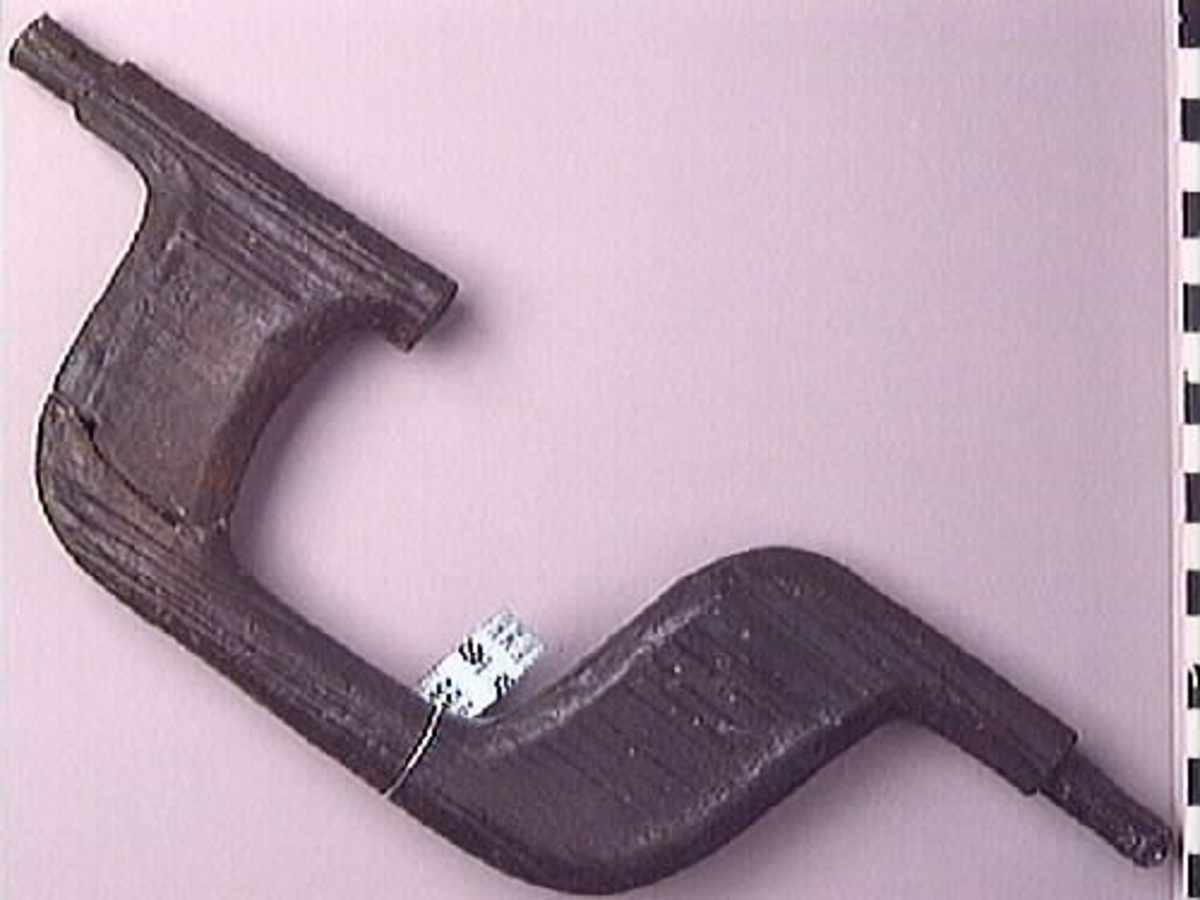 Ett skaft till en borr, sk borrsväng. Skaftet har fasade ytterkanter. Skaftet, som tidigare varit avbrutet, har fogats samman av konserveringsenheten 1996.

Skaftet är välbevarat. På skaftets yta syns blå utfällningar.

För mer information se Dokumentationsblankett under Referenser – Länkade filer.


Text in English: The handle of a brace.

Cranked wooden handle with bevelled sides. Previously broken, repaired by the Conservation Laboratory in 1996.

Well preserved. Blue precipitations on surface.

For more information see the Documentation form under References – Linked files.