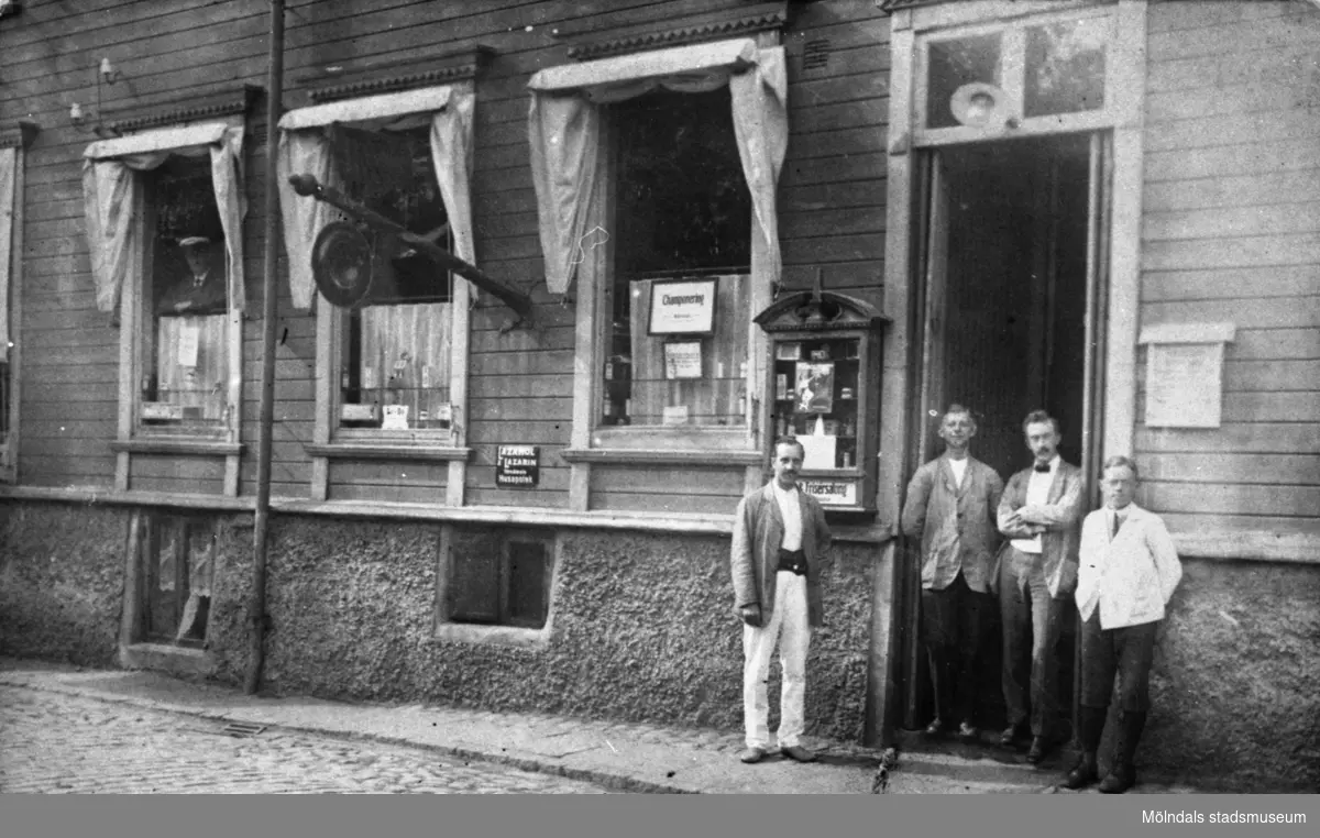 Frisersalong i Mölndals Kvarnby, troligtvis 1900-1910. Från vänster står möjlig kund, Henriksson, Widgren och tvålpojken Nils Engberg.