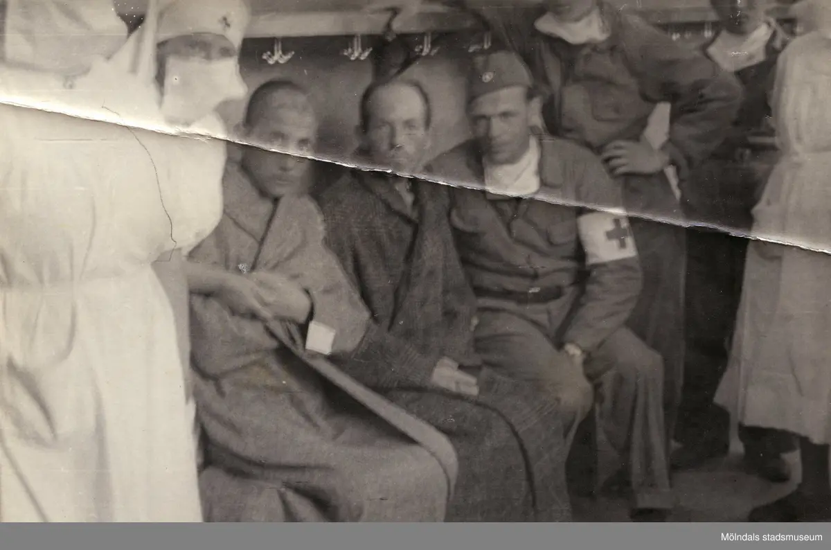 "Karantänsförläggning" på Kvarnbyskolan för överlevande från koncentrationsläger i Tyskland och Polen 1945.  
Skolan fungerade under denna sommar som beredsskapssjukhus.

Två manliga patienter omgivna av Röda Kors personal.