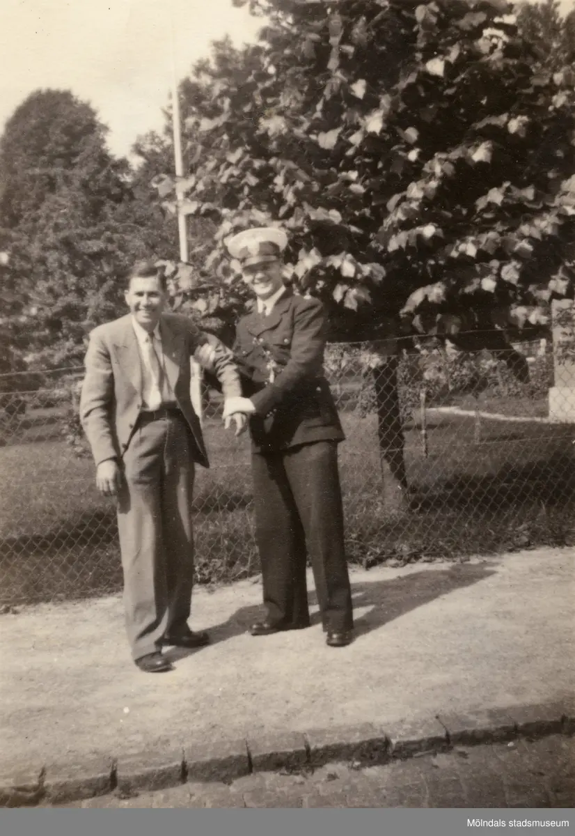 "Karantänsförläggning" på Kvarnbyskolan för överlevande från koncentrationsläger i Tyskland och Polen 1945.  
Skolan fungerade under denna sommar som beredsskapssjukhus.
 
Två män fotograferade utomhus, en av dem är Röda korset-personal.