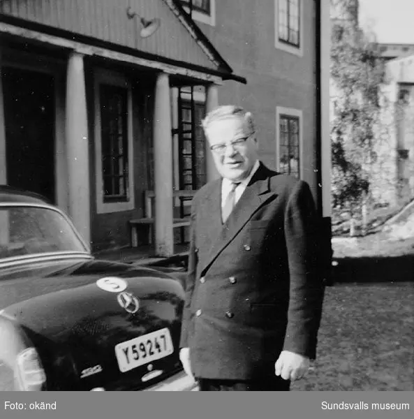 Överingenjör Fritz Bolin framför kontores huvudentré, Nensjö cellulosafabrik, Gudmundrå sn i Ångermanland, med sin tjänstebil en Mercedes 190b, 1960 års modell.