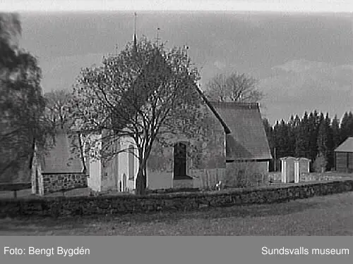 Nya och gamla kyrkan på Alnö, kyrkskolan, hembygdsgården samt intilliggande bebyggelse.