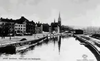 Till vänster Fisktorget med torghandel och kv Glädjen och Lyckan. Till höger Norrmalm  och i bakgrunden Gustav Adolfskyrkan. Text på vykortet 