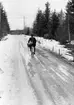 Lantbrevbärare, postiljon Erik Bergman (cykelåkande) i
Delsbo.  April 1956.

Brevbäringsturen är 2 ½ mil lång och omfattar nästan 300 hushåll. Postväskan väger ofta 30-40 kg.