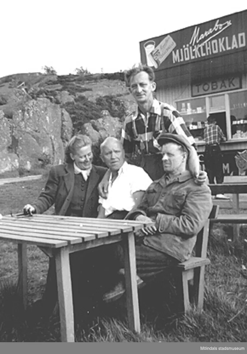 Fikapaus vid Näsets kiosk efter en trevlig fisketur, 1950-tal. Till vänster: Astrid Garthman, Charlie Magnusson och Helmer Garthman. Stående är Arne Jansson.