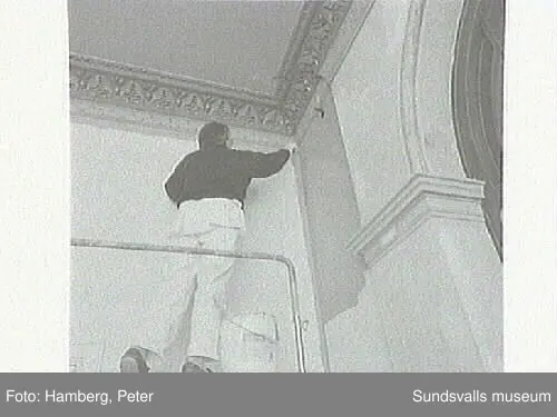 Målningsrestaurering av trapphus Storgatan 12. Eva Magnusson, praktikant från Västermalms skola, hjälper målaren Lars Erik Sjögren.