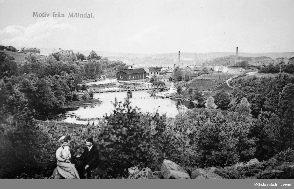 Vykort "Motiv från Mölndal" postat 28/2 1911. Utsikt från Stensjöbacke ned mot Grevedämmet, Grevedämmets järnvägsbro och Rackarebron med början av Pixbovägen. 
Man ser Lella Hölja från ovan.