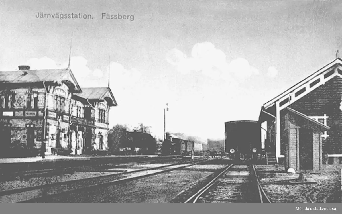 Kolorerat vykort "Järnvägsstation, Fässberg". Man ser Mölndals nedre (järnvägsstation), fotograferad från nordväst. Producerat av Jolin och Wilkenson Konstförlag, Göteborg, sänt till fröken Möller i Stockholm från Hilma i Rosenhill (Kungälv). Kortet har även märkts: G. Gunnel Dahlbeck 18/5-87.