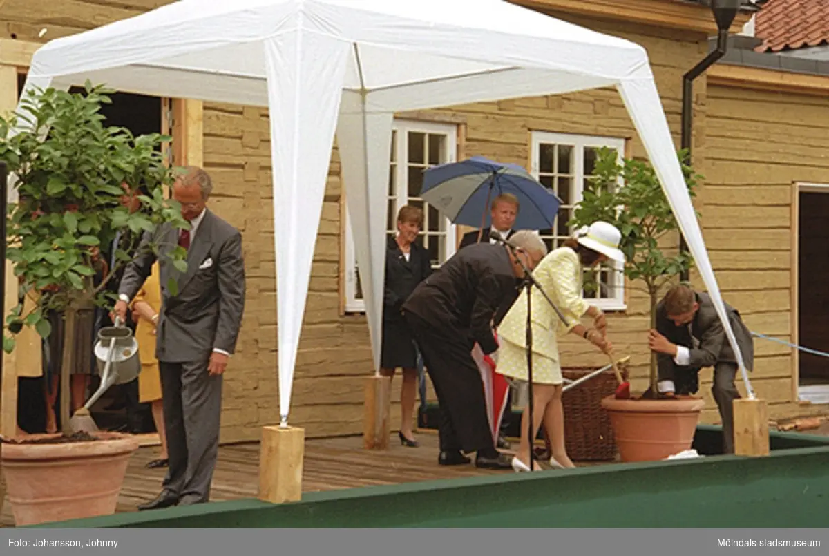 Kung Carl XVI Gustaf och drottning Silvia planterar två vårdträd/fruktträd utanför Tjenstefolksbostaden. På scenen står även landshövdingen Göran Bengtsson och Kaj Johansson.