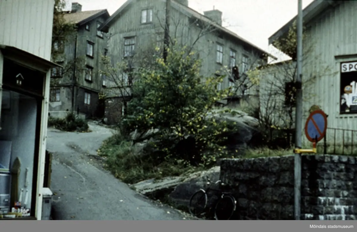 Järnhandelsliden, mellan Kvarnbygatan 27 (Johanssons järnhandel) och Kvarnbygatan 29 (gamla Rådhuset) i Mölndals Kvarnby, våren 1962. 
Även kallad Smed-Kalles lid, Spanåsliden samt Röda liden. Källa: "Mölndals gatunamn" av Lars Gahrn.