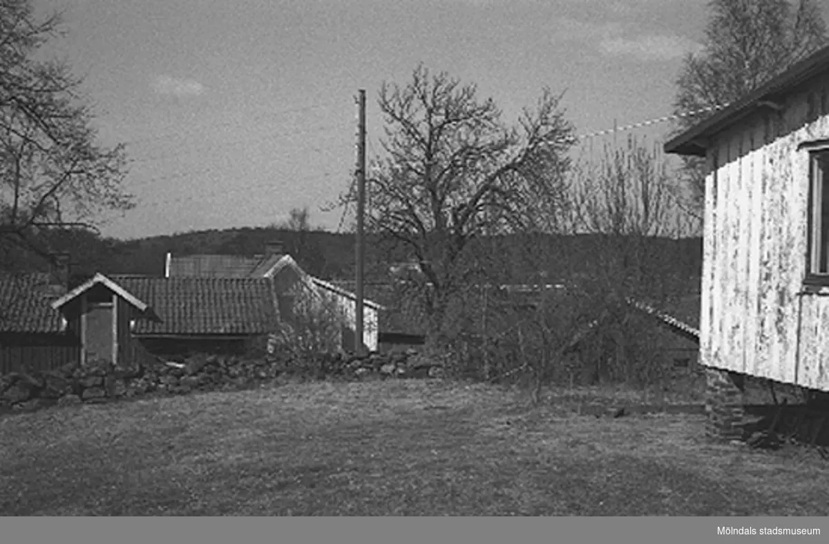 En elstolpe i trädgården, en stenmur bakom. Backen 2:3 i Kållered 1996-03-18.