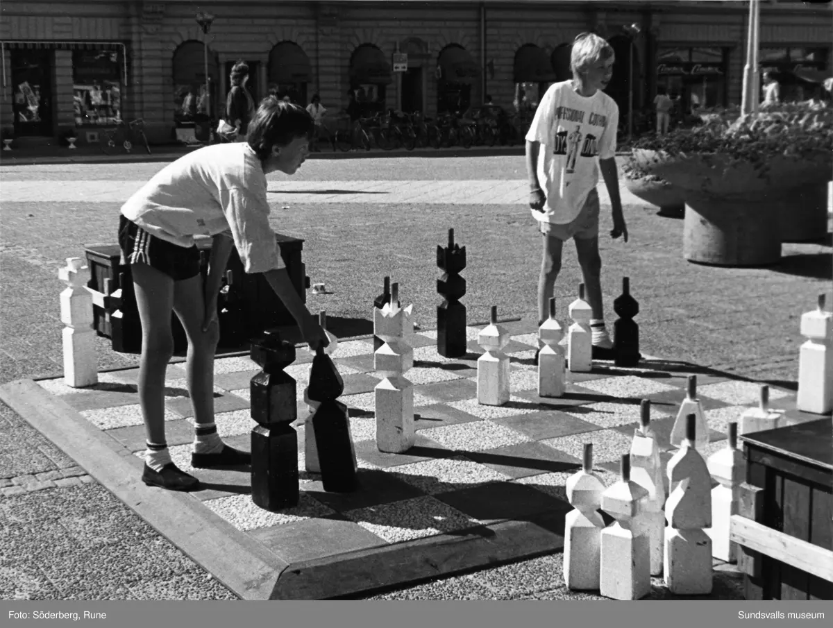 Pojkar spelar schack på Stora Torget.