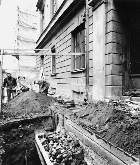 Pelarna framför entrén har tagits bort och skall ersättas med nya.
Trottoaren uppgrävd för grundförstärkning av huset. Detalj av den
uppgrävda trottoaren framför entrén.