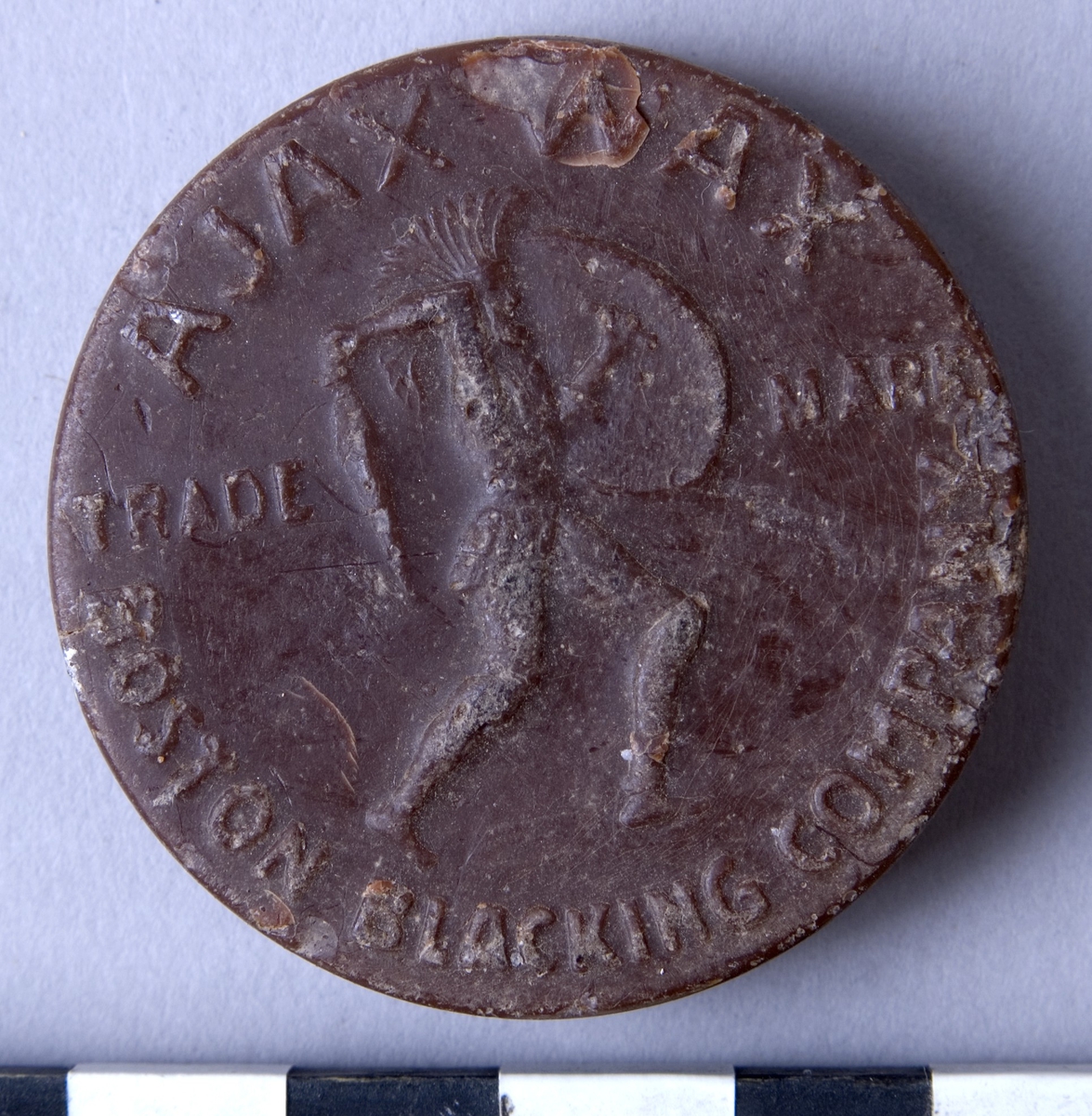 Färgvax , fyra stycken, runda kakor  av vax i olika kulörer och fabrikat.

A: Brun, "AJAX WAX" "BOSTON BLACKING CO"
B: Brun, "AJAX WAX" "BOSTON BLACKING CO"
C: Svart, "HERKULES WACHS" "SCHUTZMARKE"
D: Beige, "AJAX WAX" "BOSTON BLACKING CO"