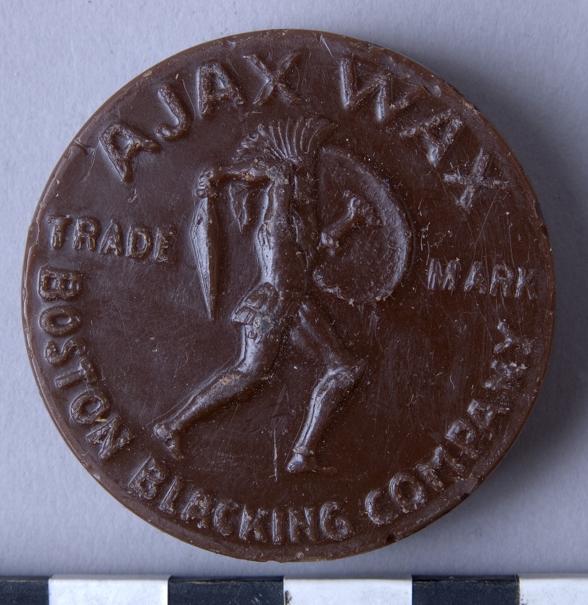 Färgvax , fyra stycken, runda kakor  av vax i olika kulörer och fabrikat.

A: Brun, "AJAX WAX" "BOSTON BLACKING CO"
B: Brun, "AJAX WAX" "BOSTON BLACKING CO"
C: Svart, "HERKULES WACHS" "SCHUTZMARKE"
D: Beige, "AJAX WAX" "BOSTON BLACKING CO"