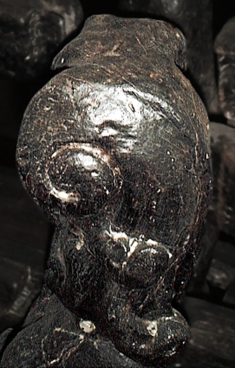 Skulptur av en triton, svängd mot höger.
Tritonen är framställd i vänster profil och avtecknar sig i hög relief mot det släta bakstycket. Tritonen har en stor näsa och treflikig mustasch. På huvudet sitter en hjälm med dekorativa bladvoluter. Armarna är ersatta av långa, flikiga bladslingor. Bålens övergång i den fjällförsedda fiskstjärten markeras av stora bladbildningar. Tritonens stjärt döljs bakom stjärten och vingen till en under liggande drake, se fyndnummer 21277. På baksidan finns urtag för relingslisten.
Skulpturen är mycket välbevarad.

Text in English: A sculpture of a Triton curved to the right.
The figure is seen in left profile, in high relief against a plain back board. The face has a large nose and a moustache that splits into three parts. On its head is a helmet with decorative leaf volutes. The arms are replaced by long, lobed leaf formations. The transition area between the male torso and the scaled fish-tail is decorated with large leaves. The rear is hidden behind a dragon''s coiled tail and broad wing situated below, see No. 21277. There are notches on the back that fit into the railing.
The sculpture is very well preserved.