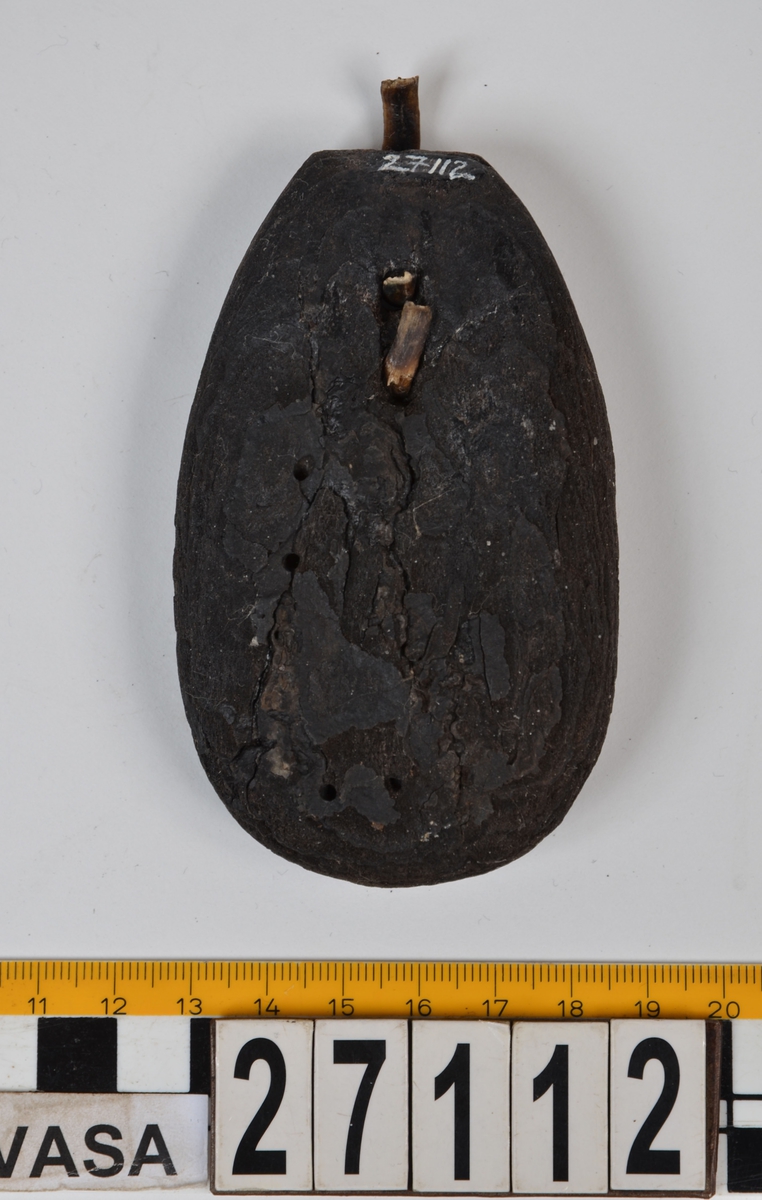 Ett ovalt flöte av bark. I flötets övre del finns två mindre hål, med kvarsittande band av rot. Flötet är välbevarat.