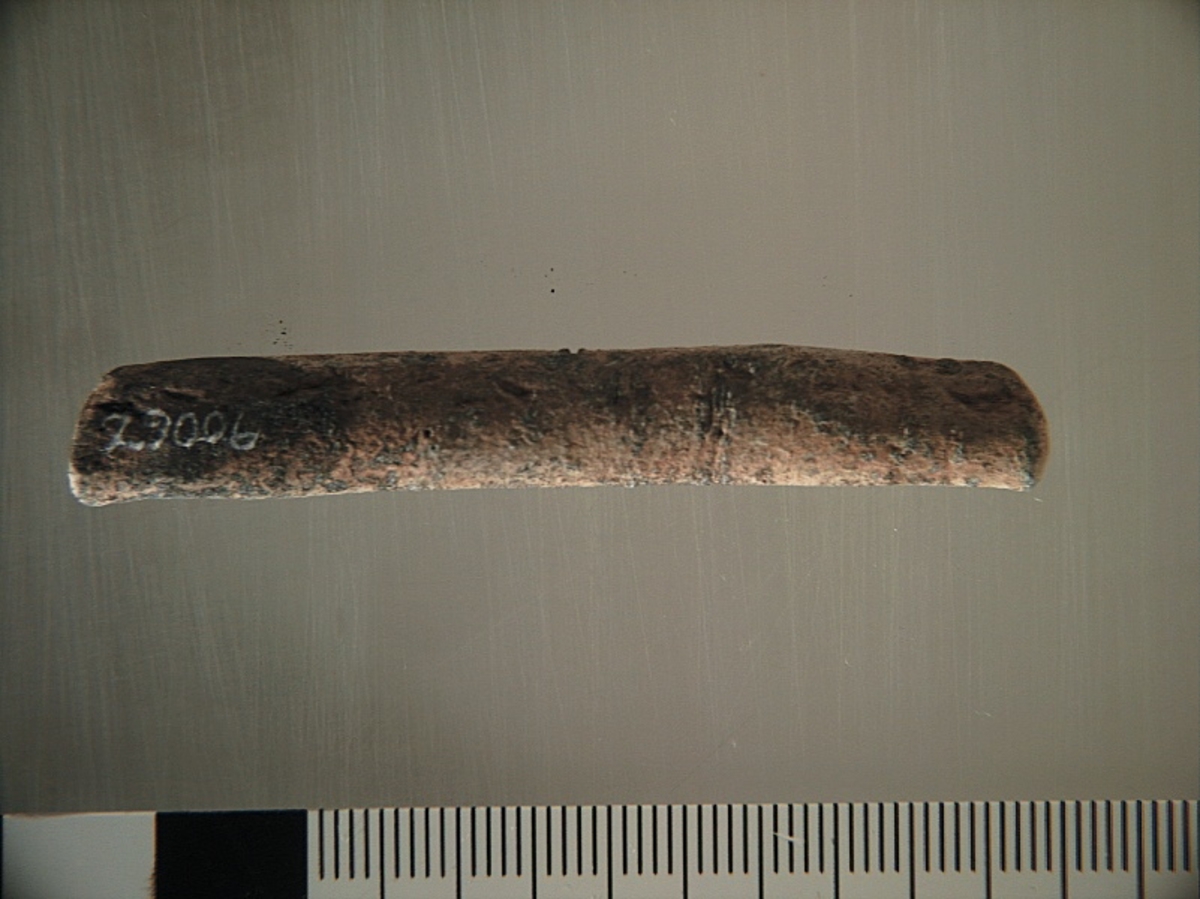 Sänket består av vikt blybit. Sänket har tydliga märken efter det verktyg som pressat ihop sänket runt garntråden. Sänket är i gott skick.

Text in English: Lead sinker in the shape of a flat tube. The rectangular piece of lead is folded vertically in half and has visible tool marks from the folding process. The yarn is pushed through the hole. Grey mat in colour. In good condition.