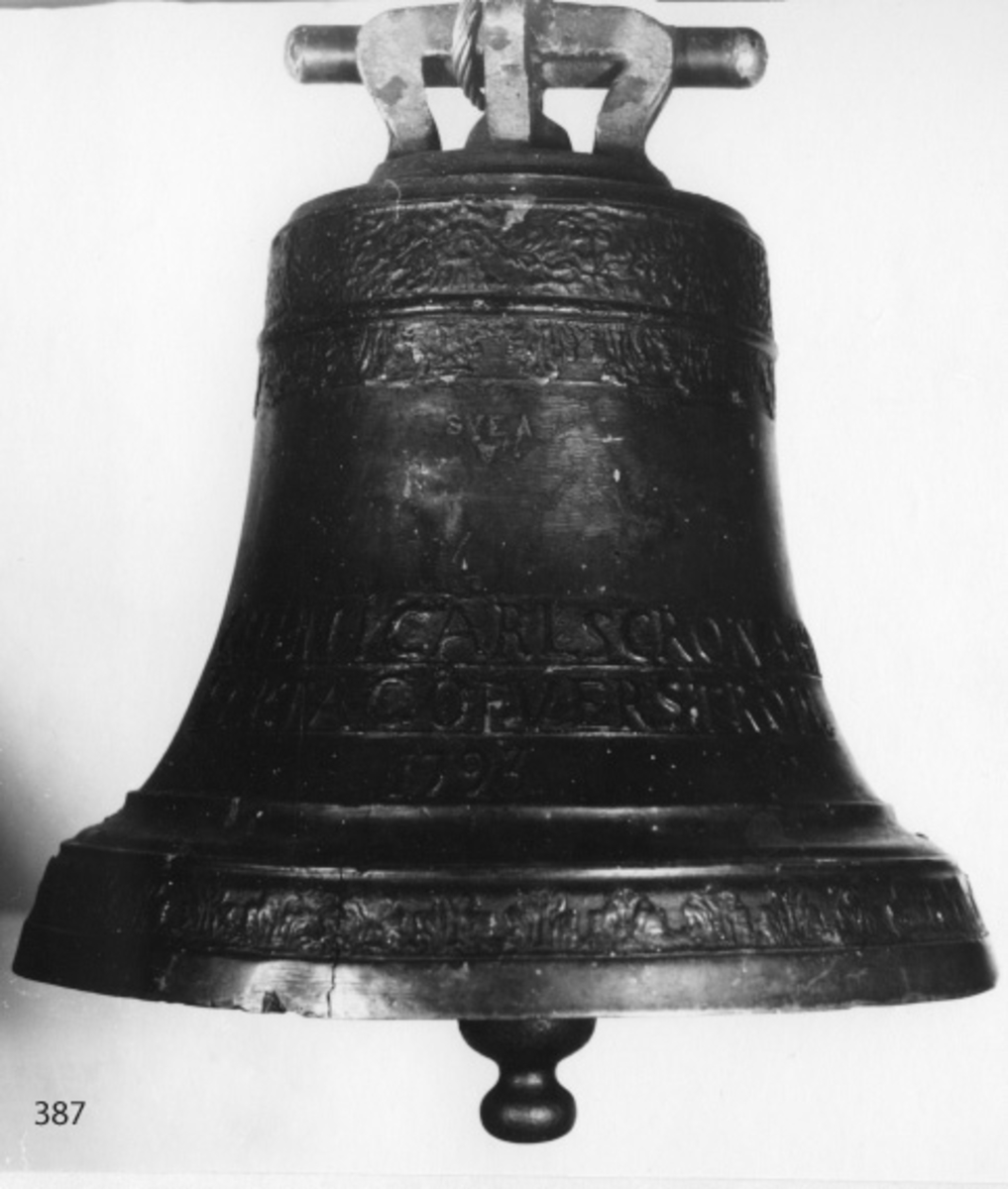 Skeppsklocka, av metall, gjuten år 1793, med följande inskription å ena sidan: "Gjuten i Carlskrona hos Marta C. Öfverström 1793". Å andra sidan ett namnchiffer "RGA" med kunglig krona över.
