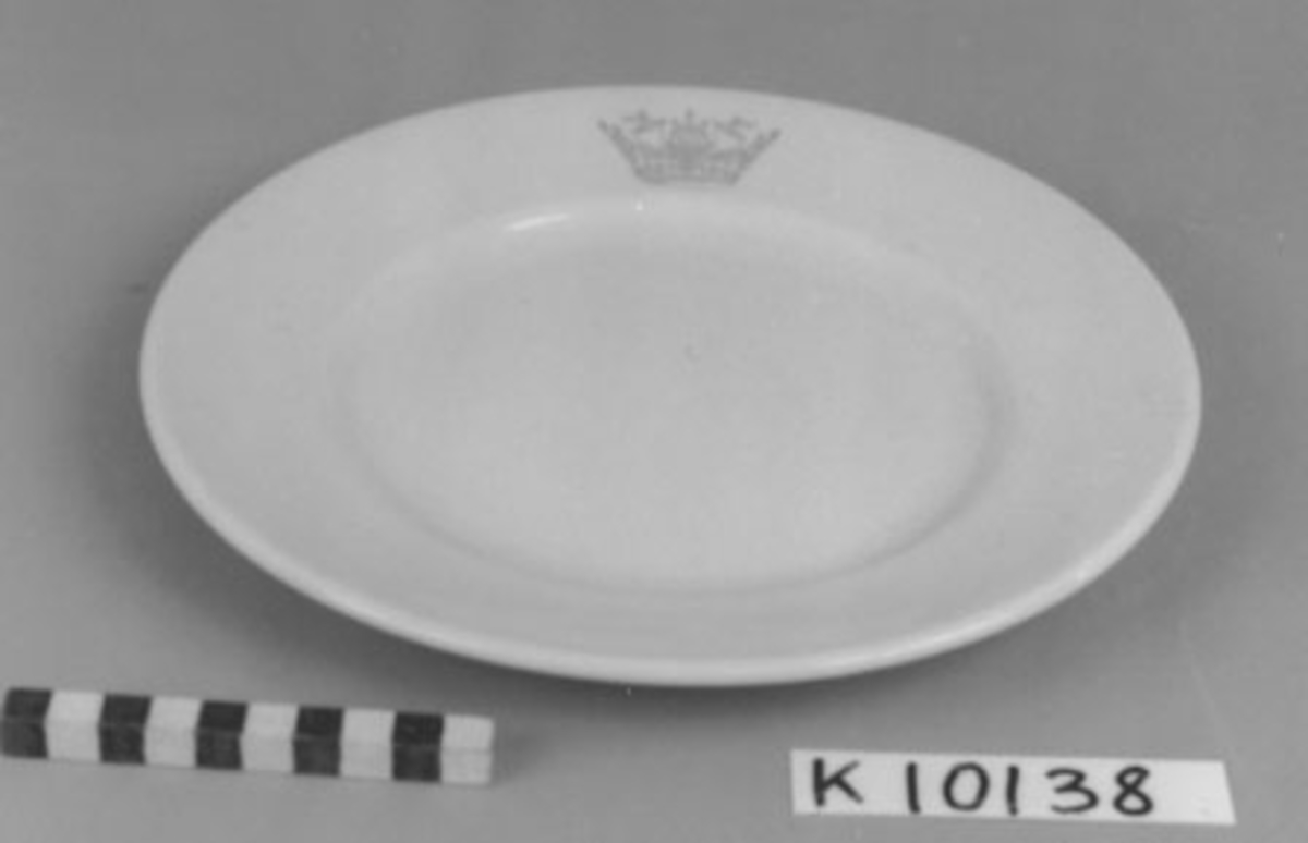 Tallrik, flat- av porslin. Dekorerad med seglarkrona i blått. Märkt i botten UE Uppsala-Ekeby Karlskrona.